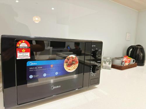 a microwave with a pizza inside of it at SummerDay Seaview Studio Apartment at Kota Kinabalu City Centre in Kota Kinabalu