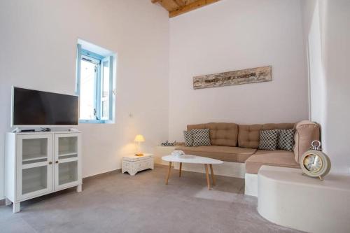 a living room with a couch and a tv at Traditional Luxury House in Kalithies