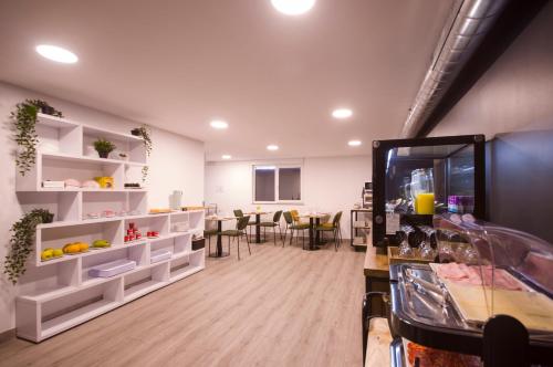 a room with white shelves and a dining room at U-Hotel Darío Lugo in Lugo