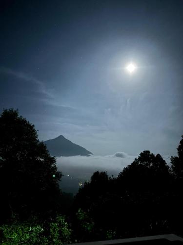a full moon rising over a foggy valley at night at Willow Nest in Anachal