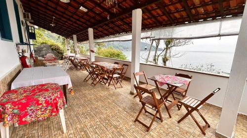 阿拉夏奇巴海滩Pousada Canto do Mar Ilha Grande的阳台配有桌椅,享有水景。