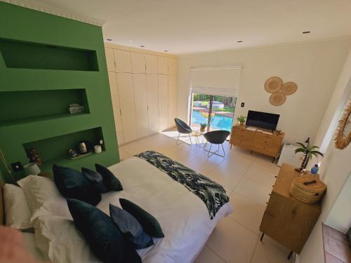 a bedroom with a large bed with a green headboard at Die Regte Rede in Cape Town