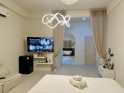 a white room with a bed and a tv at 24Rooms นครสวรรค์ in Nakhon Sawan