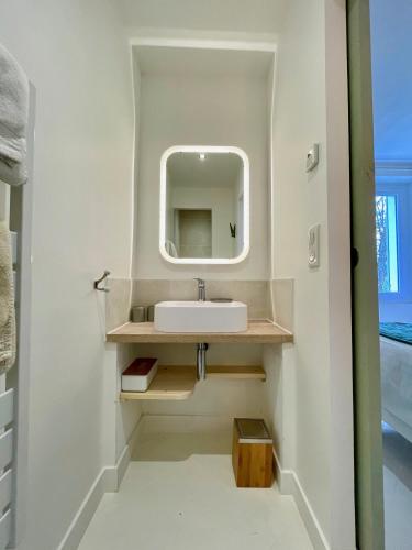 une salle de bain avec un lavabo et un miroir dans l'établissement Mazet avec piscine, parking et clim dans le centre, à Saint-Rémy-de-Provence