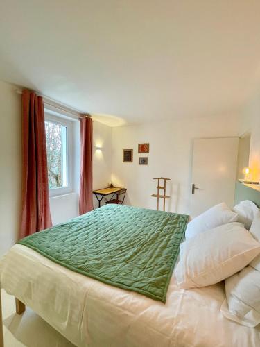- une chambre avec un grand lit et une couverture verte dans l'établissement Mazet avec piscine, parking et clim dans le centre, à Saint-Rémy-de-Provence