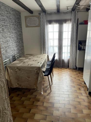 d'une salle à manger avec une table, des chaises et un mur en briques. dans l'établissement Rahou, à Étampes