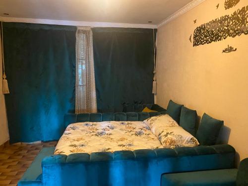 - un canapé bleu dans le salon avec un lit dans l'établissement Rahou, à Étampes