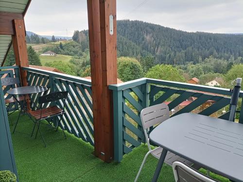 un balcone con tavolo e sedie e vista di Appartement GERARDMER - Magnifique vue sur le lac - jusqu'à 4 personnes a Gérardmer