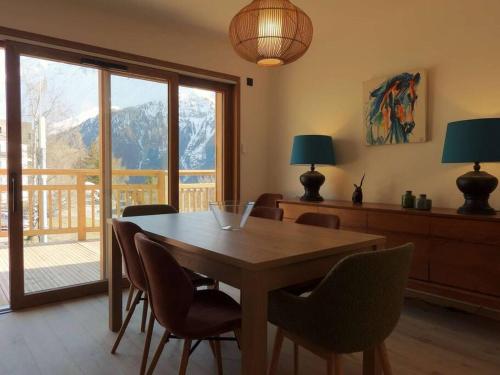 - une salle à manger avec une table et des chaises offrant une vue dans l'établissement Paradiski nouveau, cosy et ensoleillé plan Peisey, à Peisey-Nancroix