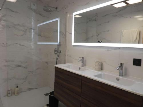 une salle de bain blanche avec un lavabo et un miroir dans l'établissement Paradiski nouveau, cosy et ensoleillé plan Peisey, à Peisey-Nancroix