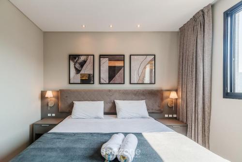 a bedroom with a bed with two pillows on it at MHF II - Apts Variados em Prédio com Vista para o Mar em Itapema in Itapema