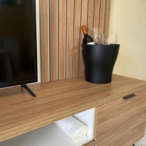 a bottle of wine sitting on a table next to a television at Pousada Paraíso do Banana - Lagoa do Banana in Caucaia