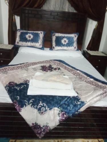 a bed with a blue and white blanket on it at Nubian Life Nile View in Aswan