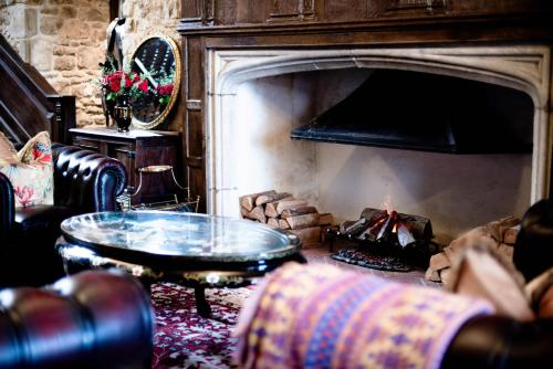 a living room with a fireplace and a couch and a table at Stone Court House in Maidstone