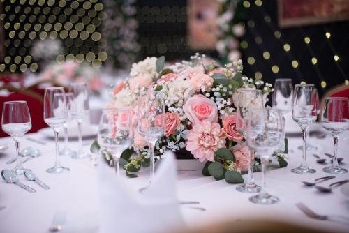 a table with glasses and a bouquet of pink roses at Stone Court House in Maidstone