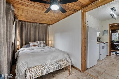 a bedroom with a bed and a white refrigerator at Cool Moss Stone Lodge Wkayaks & Canoes in Karnack