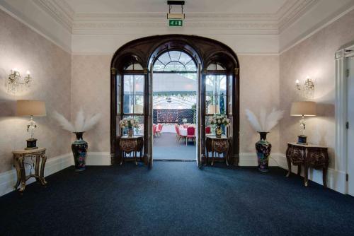 a room with an open door with tables and chairs at Stone Court House in Maidstone