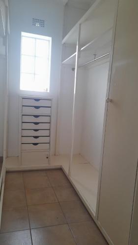 a walk in closet with a window and a mirror at Rondebosch Gardens in Humansdorp