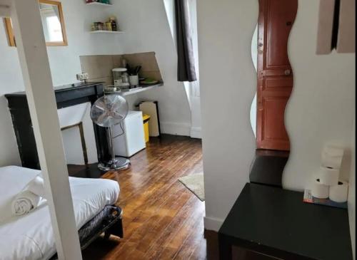- un salon avec un bureau et un ventilateur dans l'établissement Backpacker room with an Eiffel Tower view near St Germain des Prés, à Paris