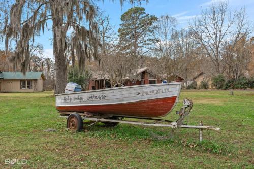 a small boat sitting on a trailer in a field at Cool Moss Stone Lodge Wkayaks & Canoes in Karnack