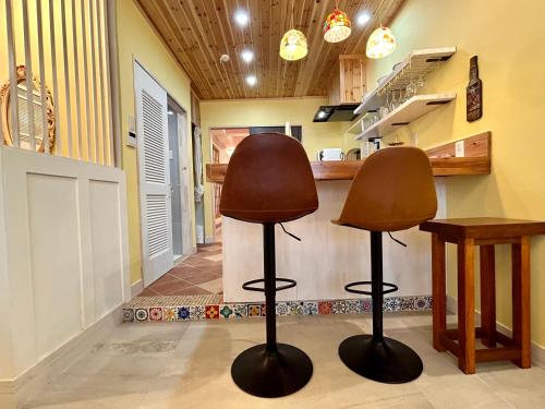 two chairs in a kitchen with a counter at 若狭の家 in Naha