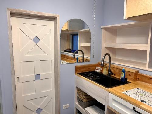 a kitchen with a white door and a sink at 若狭の家 in Naha