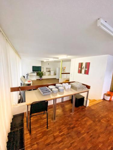 a living room with a table and a kitchen at Alpine Clubhouse in Leysin