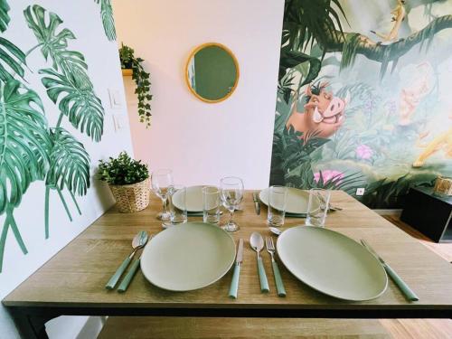 une table en bois avec des plaques blanches et de l'argenterie dans l'établissement La Jungle de Simba ! Disneyland Paris, à Montévrain