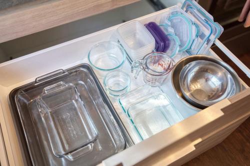 eine Schublade mit Gläsern und Geschirr in einer Küche in der Unterkunft Historic 1Bdrm - Parking - Walk to Restaurants & Westport! in Kansas City