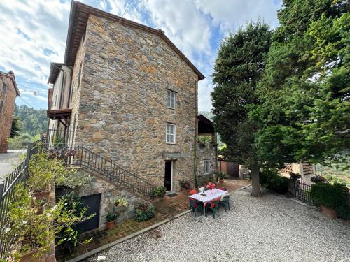 a stone house with a table in front of it at Casa Max in Capannori