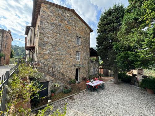 a stone house with a table in front of it at Casa Max in Capannori