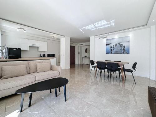un salon avec un canapé, une table et des chaises dans l'établissement INTUITION - 3 pieces - 10min Croisette, à Cannes