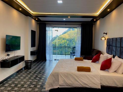 a bedroom with a large bed and a balcony at Paraiso Guest House in Ella