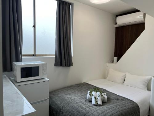 a hotel room with a bed and a tv at Ikebukuro Area R1 NishiikeApartment 5F No Elevator in Tokyo