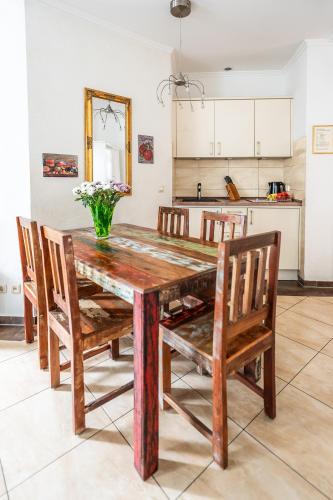 a dining room table with chairs and a vase of flowers at Villa Backstein OBO19 in Schwerin
