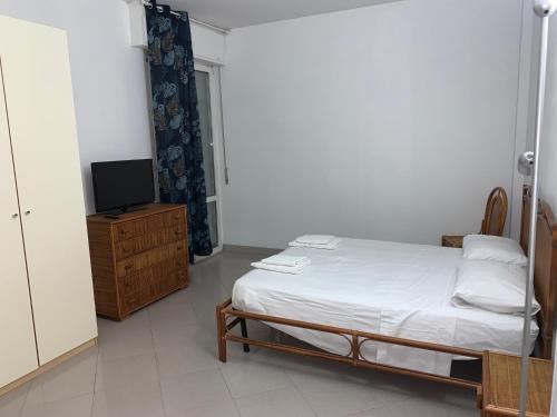 une chambre avec un lit et une télévision sur une commode dans l'établissement Hawaiian Apartment, à Florence