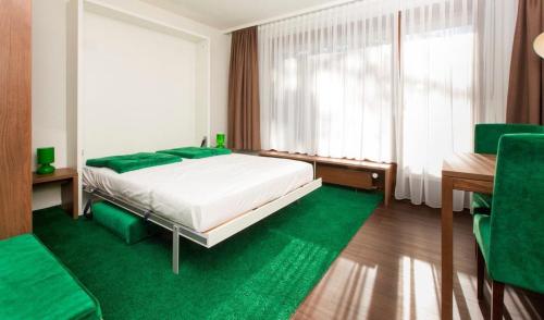 a bedroom with a bed and a desk and a green rug at Residence Caddies Club in Crans-Montana