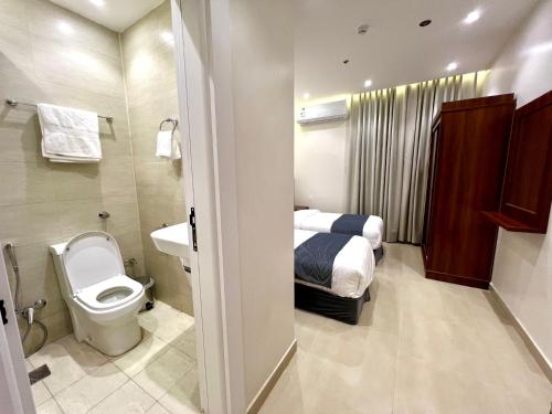 a bathroom with a bed and a toilet and a sink at New Karam Suites in Riyadh
