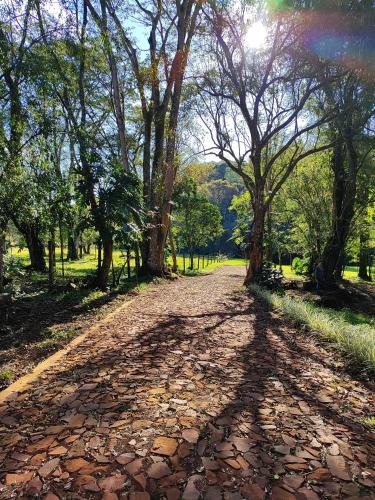 a dirt road with trees and a rainbow in the background at Cabañas Nueva Alborada in Nueva Alborada