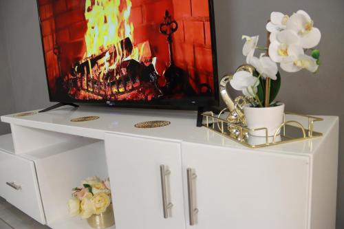 a white entertainment center with a tv on top at Luxuryo in Zeerust