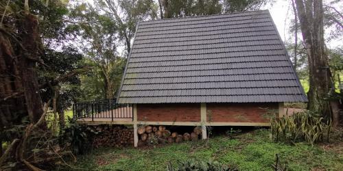 a red brick house with a black roof at Cabañas Nueva Alborada in Nueva Alborada