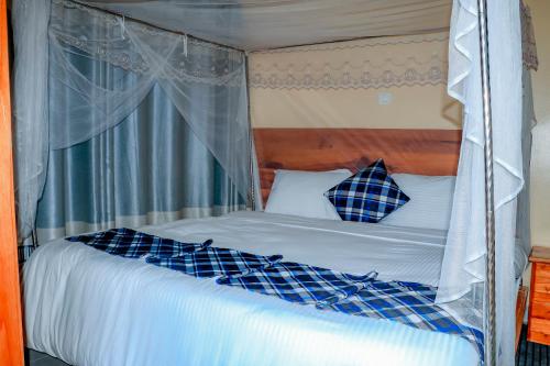 a bedroom with a canopy bed with blue and white pillows at Home Saint Jean Ltd in Gitesi