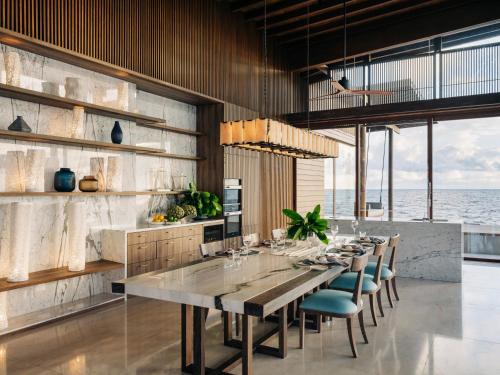 a dining room with a long table and chairs at Park Hyatt Maldives Hadahaa in Gaafu Alifu Atoll
