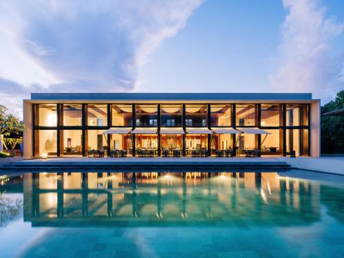a large building with a pool in front of it at Park Hyatt Maldives Hadahaa in Gaafu Alifu Atoll