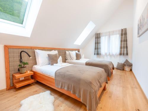 two beds in a bedroom with a skylight at Residence Soča in Soča