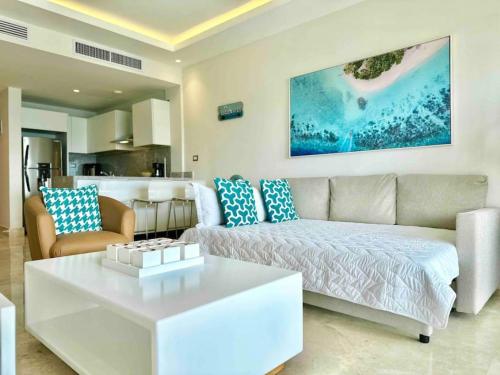 a living room with a couch and a coffee table at Stunning Bay View Condo, Pool in Santa Bárbara de Samaná
