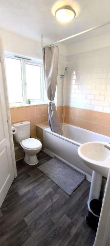 a bathroom with a tub and a toilet and a sink at 4 beds spacious Apartment, with Parking & WIFI, CHAFFORD HUNDRED, near station & shopping, long stays! in West Thurrock