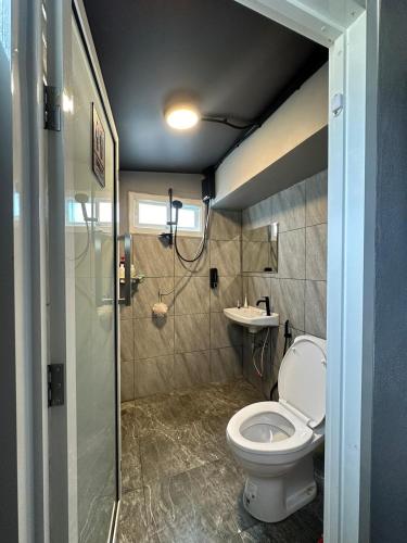 a bathroom with a toilet and a sink at Friends Station Tukkom Hostel & Cafe in Pattaya South