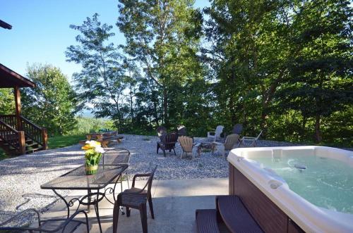 a backyard with a hot tub and a table and chairs at Goldies Hideaway in Bryson City