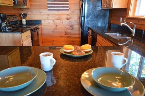 a kitchen with two plates of donuts and two cups of coffee at Goldies Hideaway in Bryson City